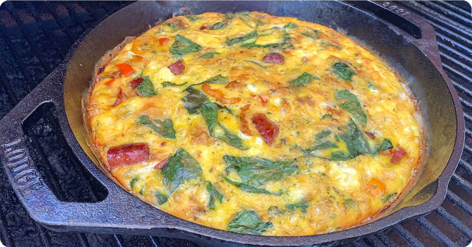 A cast iron skillet with golden brown egg frittata in it.